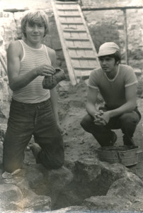 Egils Jemeļjanovs (no labās) un Jānis Ciglis pie 1982. gada izpētes laikā atrakstās mazās “aciņas”, kurā iekšā tika uziets viens no tās vasaras ievērojamākajiem atradumiem – akmensmasas keramikas krūze. (14.gs.). 